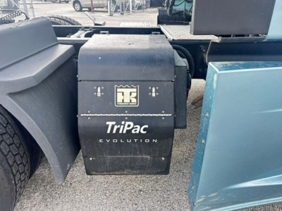 Truck side view showing TriPac Evolution and Kell manufacturer unit mounted between cab and sleeper of a Freightliner Cascadia 126 with wheel and mudguard visible.