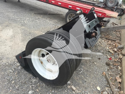 Talbert flip axle showing large dual tires and mounting bracket in a used trailer component.