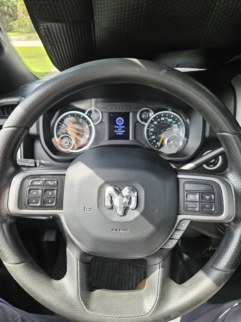 Steering wheel of a 2021 Dodge Ram shown from driver seat with instrument cluster and center display visible.