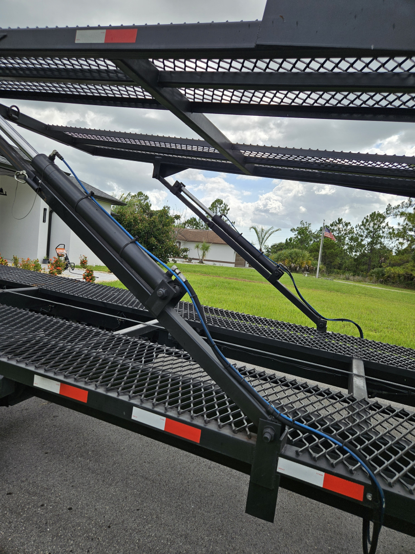 Truck equipment: a car hauler or tow bed with hydraulic arms and metal grated platform