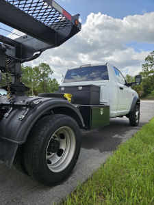 Truck bed setup with white Dodge Ram 2021, side view showing tool chest and wheel fender in foreground