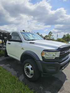 2021 Dodge Ram truck in white with black grille and fender, front-left view, badge on side, large side mirrors.