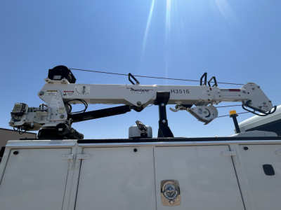 Mack MD642 boom crane mounted on service truck bed showing hydraulic arm and controls.