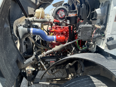 Mack MD642 engine bay showing red engine block with blue intercooler hose, black wires, and assorted components.