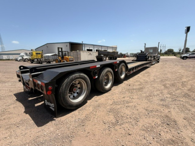  Fontaine MAG55H lowboy trailer with triple-axle configuration, visible tires, wheels, and deck in a yard.