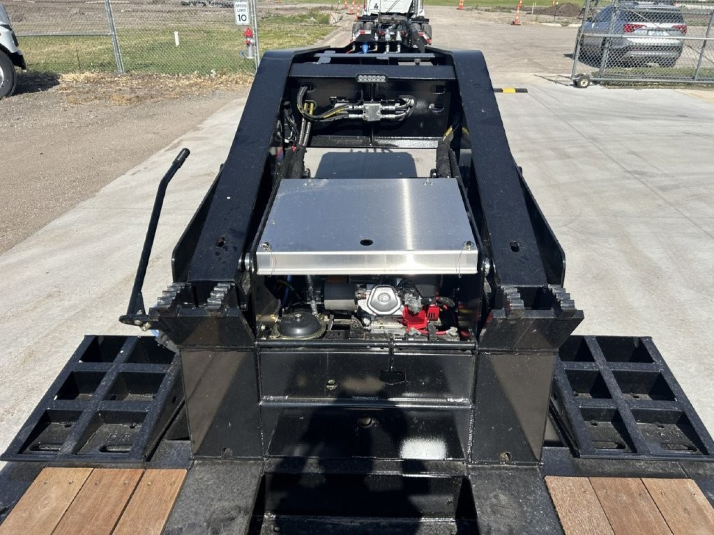 Trailer hitch mounting area with hydraulic tank and metal framework; 18-inch LDH lowboy trailer components visible.