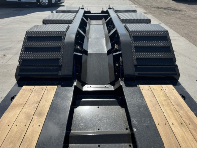 Trailer deck with heavy-duty LDH Lowboy spacers and wood-planked ramps showing rugged steel components and textured fenders.