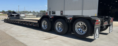 Trailer showing Alpha A110HDG-SF-18" LDH lowboy trailer with triple axles and long deck.