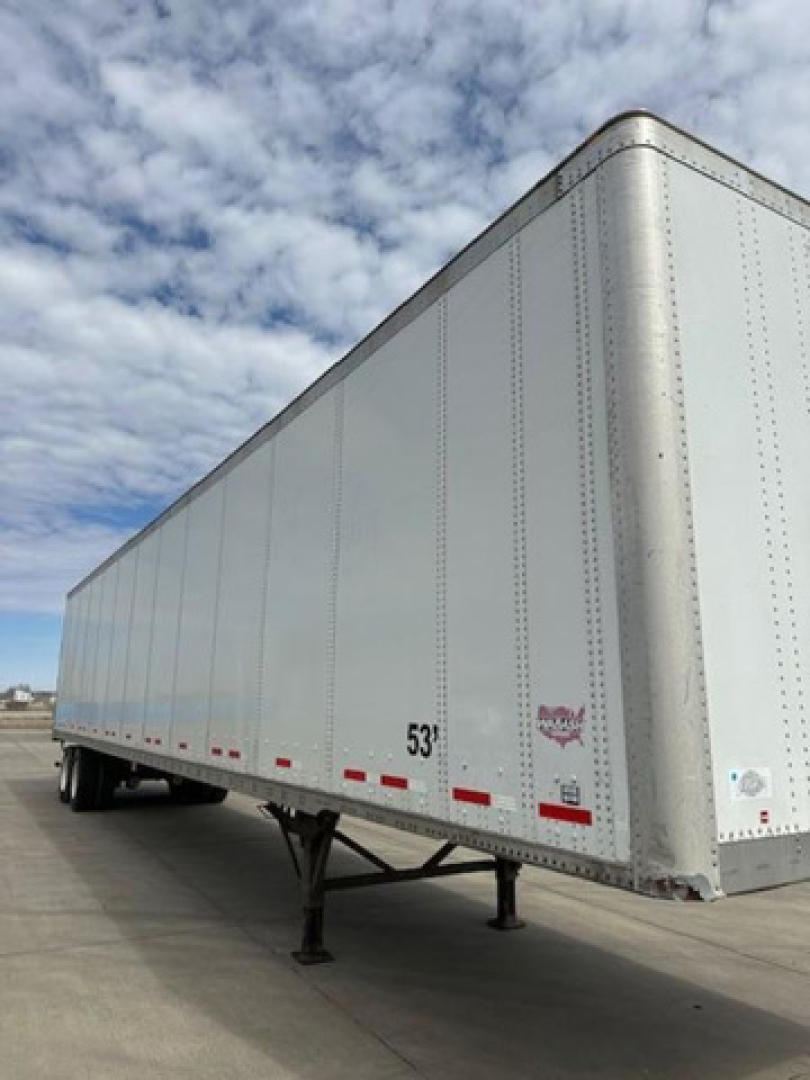 Trailer side view showing 53' Wabash van trailer with landing gear, front corner, and reflective decals.