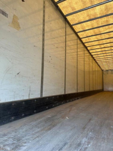 Trailer interior showing long empty cargo area with side walls and ribbed ceiling