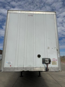 Rear view of a 2014 Wabash van trailer with riveted aluminum skin, rear doors, and utility connections at lower right.