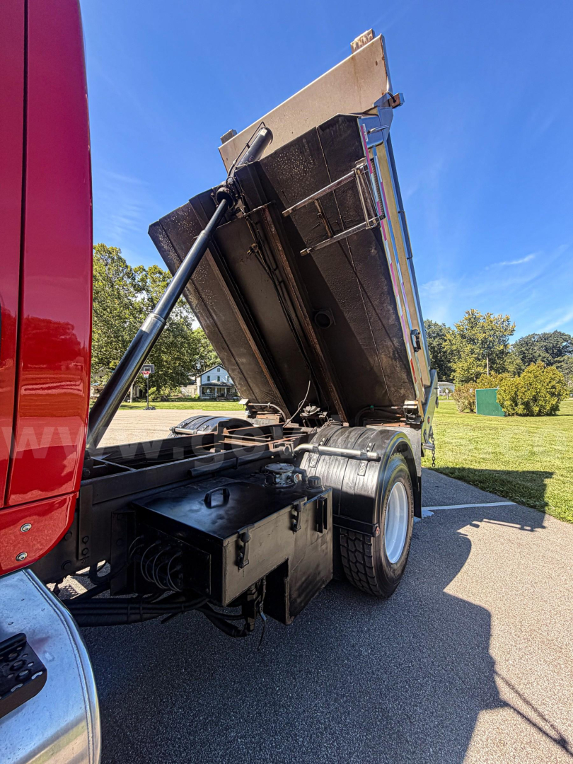 Trailer/Truck rear showing dump bed in raised position with hydraulic strut and dual rear wheels.