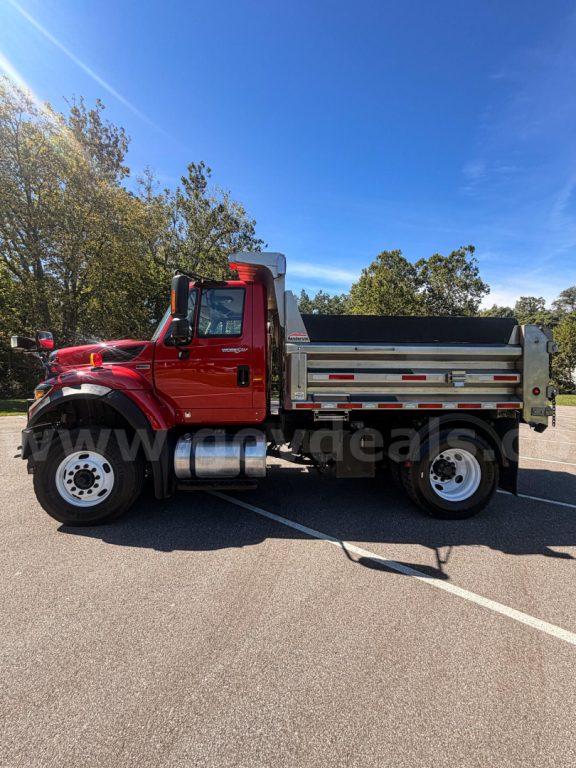 Truck cab and dump body side view showing red Internationals 7400 with silver dump box and chrome exhaust tank in daylight.