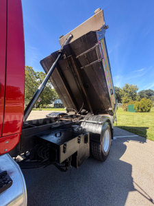 Trailer/Truck rear showing dump bed in raised position with hydraulic strut and dual rear wheels.