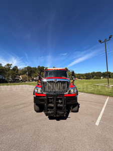 International 7400 truck front view in parking lot with plow mounting and bold grille.