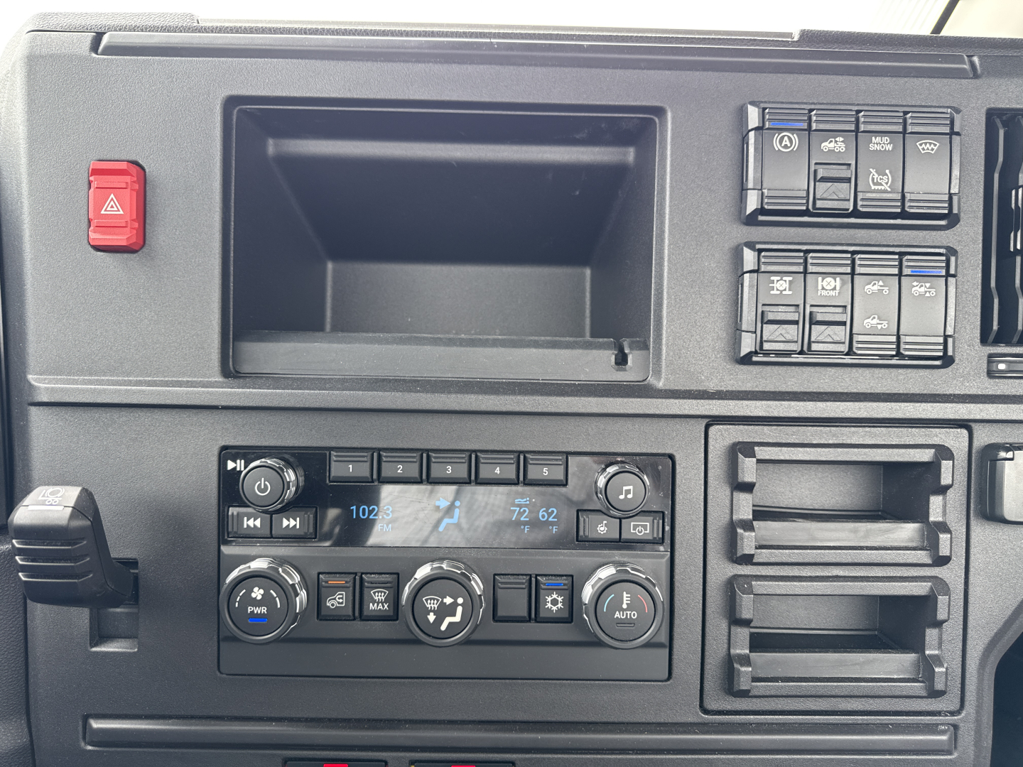 Dashboard and control panel of a Mack AN64T daycab interior showing climate controls, radio, and storage compartments.