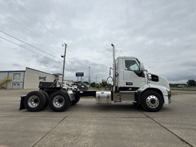 Mack AN64T conventional daycab truck side view showing tractor with white cab and dual rear axles, fuel tank, and exhaust stack.