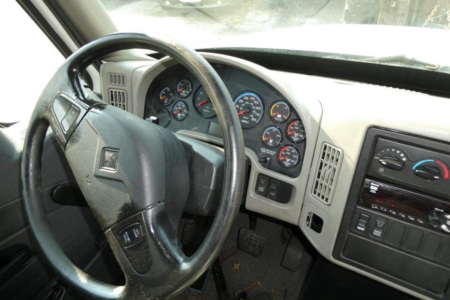 CAB interior showing steering wheel and instrument cluster of a 2017 International 4300 SBA truck.