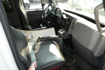 Interior of a 2017 International 4300 SBA truck cabin showing driver seat, steering wheel, dashboard, and center console.