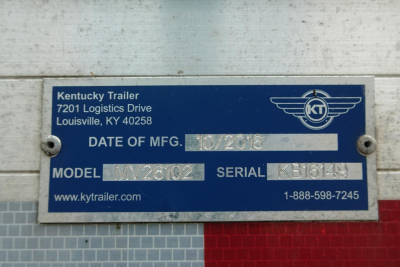 Blue Ky trailer data plate with Kentucky Trailer logo showing Date of Mfg, Model, Serial, and contact info. Text includes Kentucky Trailer, 7201 Logistics Drive, Louisville, KY 40258, DATE OF MFG: 10/2018 (blurred), MODEL: ???, SERIAL: ???,