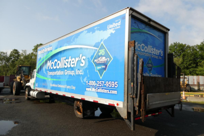 Box truck trailer with McCollister’s Transportation Group branding and United Van Lines logo, rear view showing McCollister’s text and phone number.