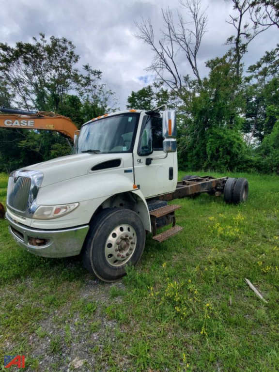 International DuraStar 4400 cab and chassis truck in a field, angled front-left view with no cargo, chassis exposed.
