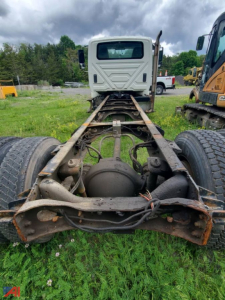 Cab and chassis rear view showing drivetrain and frame on International DuraStar truck. Visible components include rear axles, differential, leaf springs, and wiring harnesses.