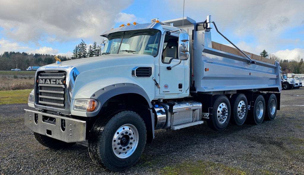 Mack GR104F dump truck showing front grille, cab, and dump bed with multiple axles.