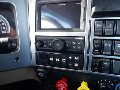 Truck dashboard showing gear selector with R N D, drive mode, and a Mack touchscreen display.