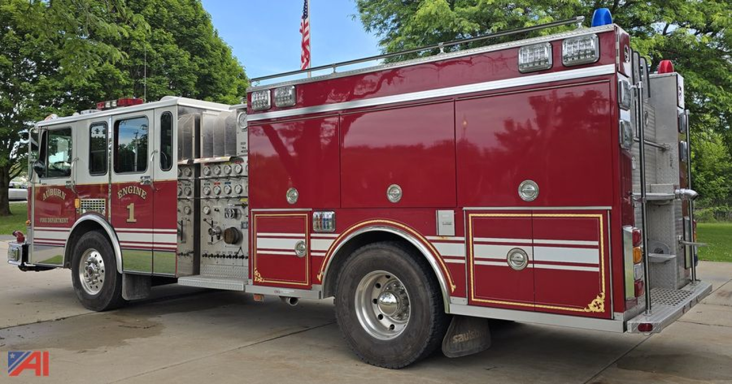 Fire truck side view showing ladder compartments and red body with white trim, Spartan Gladiator Saulsbury pumper truck