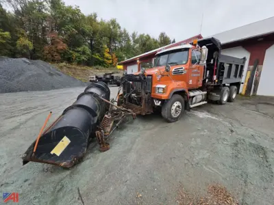 2018 Western Star 4700 dump truck with a snow plow attachment and front end loader in an industrial yard.