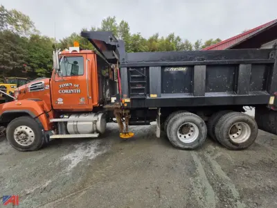 Truck side view showing 2018 Western Star 4700 dump truck with orange cab and black dump bed, dual rear axles, VIN plate area not legible.