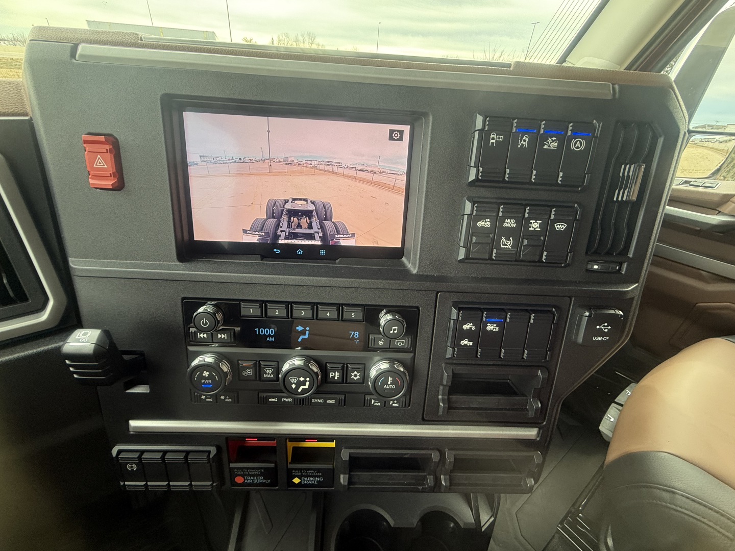 Truck interior dashboard with infotainment screen and control panels; various switches and climate controls visible.