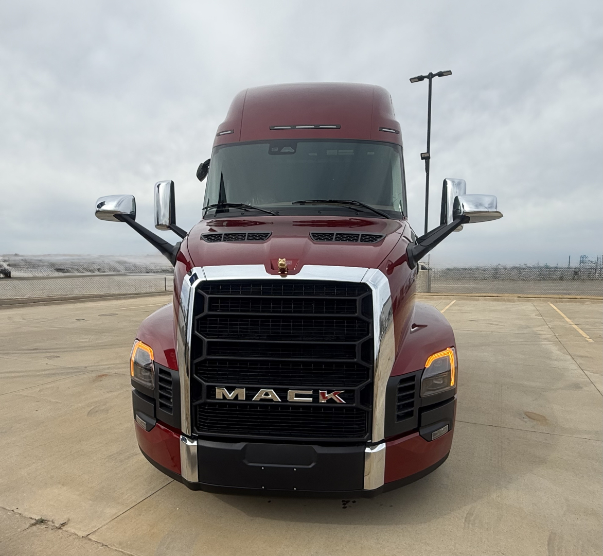 Mack PR64T76H conventional sleeper truck front view with maroon cab, chrome grille, large bumper, and headlamps.