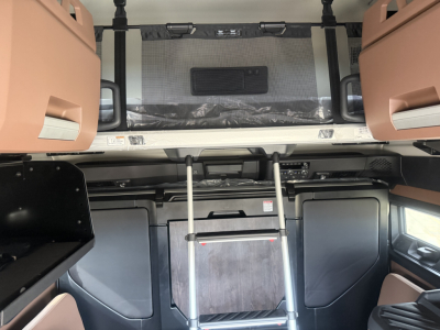 Cab interior of a 2026 Mack PR64T76H sleeper truck showing bunk area, ladder, and storage cabinets.