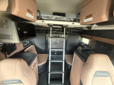 Mack PR64T76H interior cabin view with ladder, brown leather seats, overhead storage, and cockpit area.