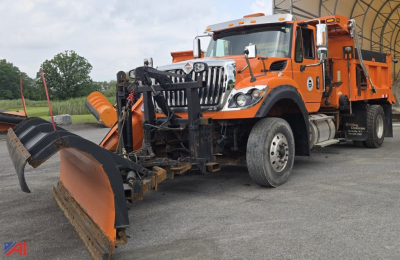 Dump truck with plow attachment in front, orange International 7600 SFA, side view showing snowplow equipment and front blade.