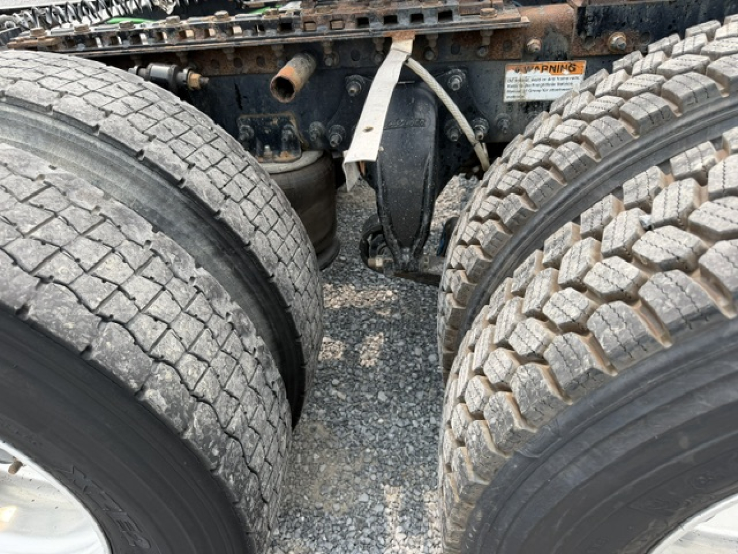 Freightliner Cascadia CA125DC undercarriage showing dual rear axle tires and suspension components.