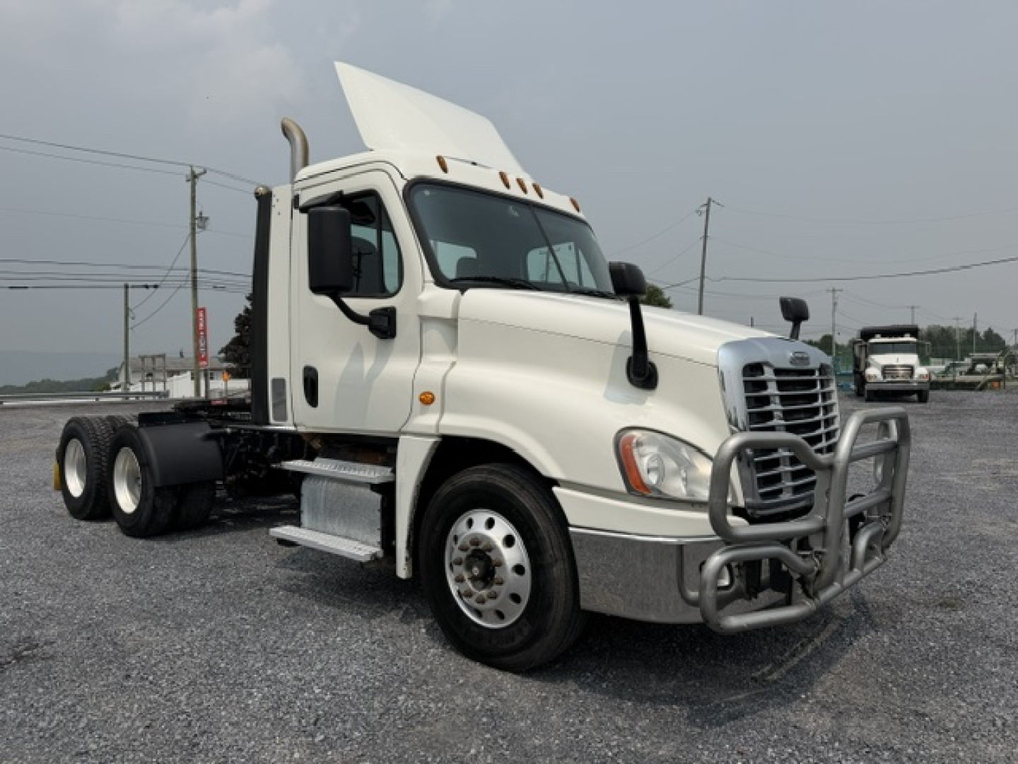 White 2017 Freightliner Cascadia CA125DC day cab truck with hood open and front guard; no visible text on panels.