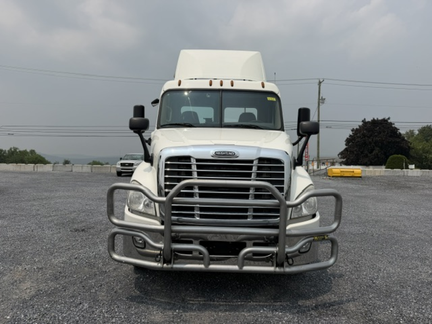 Front view of a white 2017 Freightliner Cascadia CA125DC conventional daycab truck with a large aftermarket grille guard.