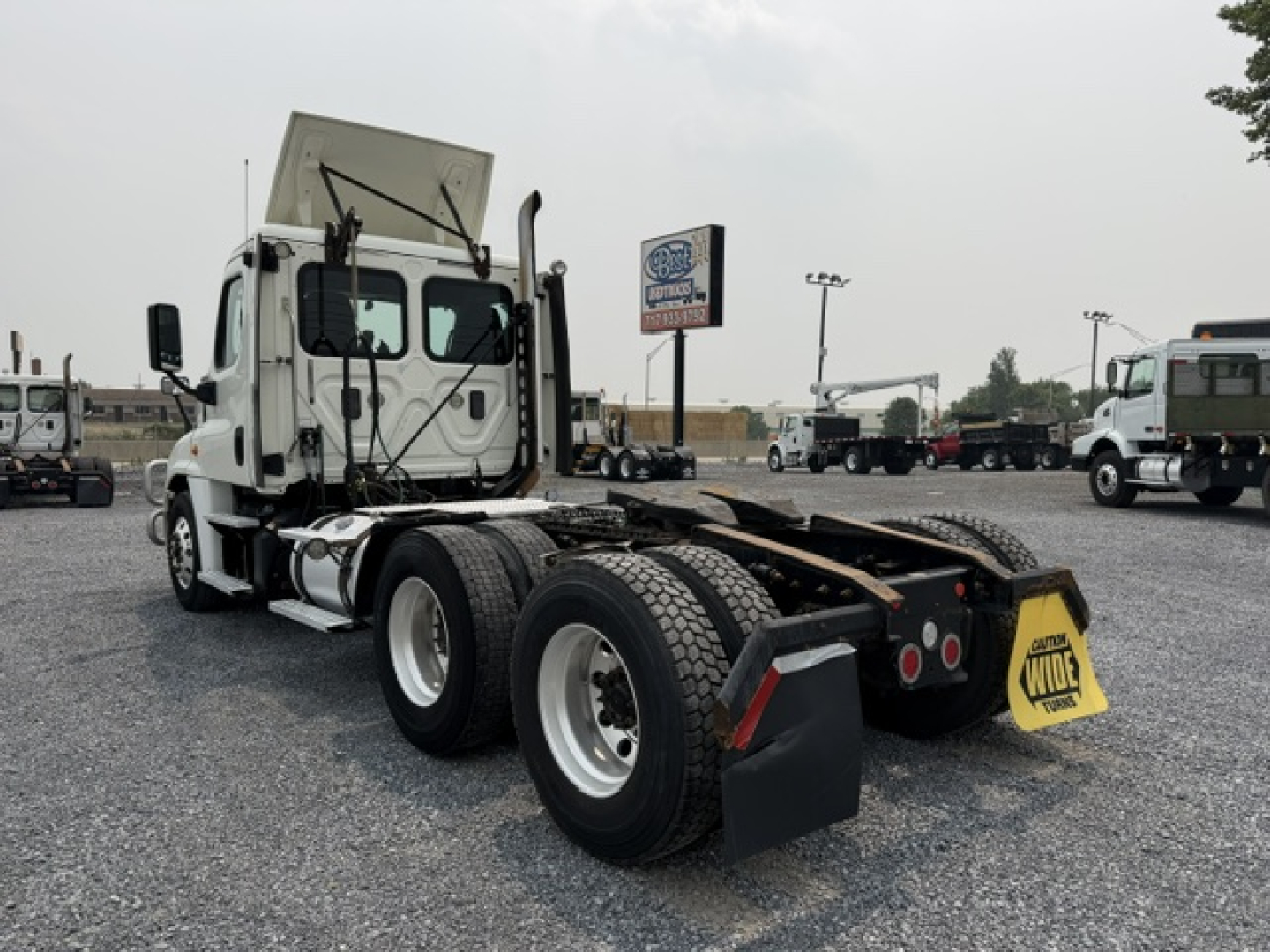 Freightliner Cascadia truck tractor rear view showing fifth wheel and dual rear axles with mud flaps and bumper.