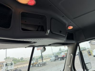 Cab interior overhead view showing storage compartments and sun visor in a Freightliner Cascadia daycab.