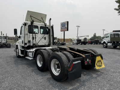 Freightliner Cascadia truck tractor rear view showing fifth wheel and dual rear axles with mud flaps and bumper.