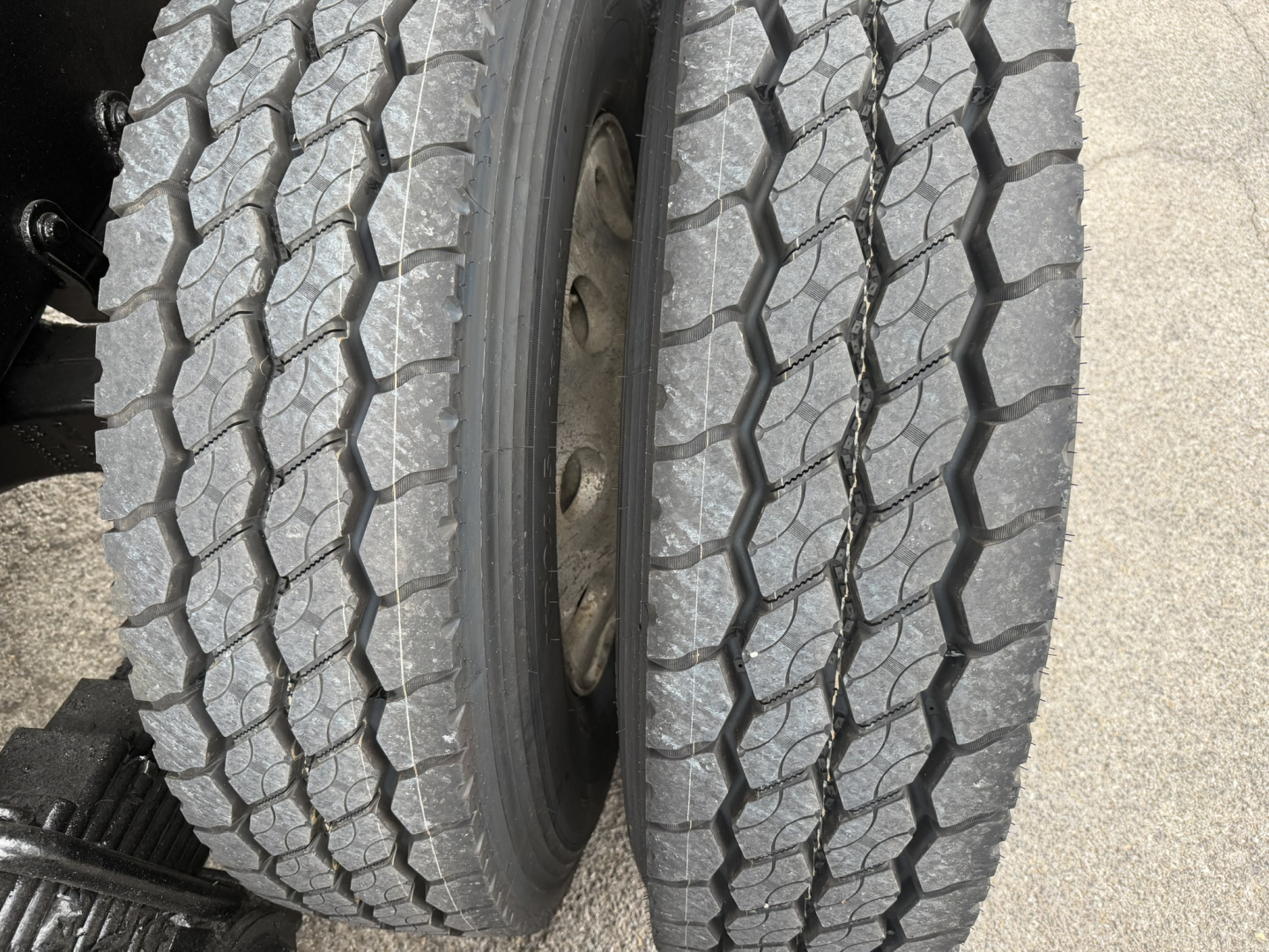 Two truck tires with treads visible on a Mack GR64F chassis; no legible text from labels visible in image.