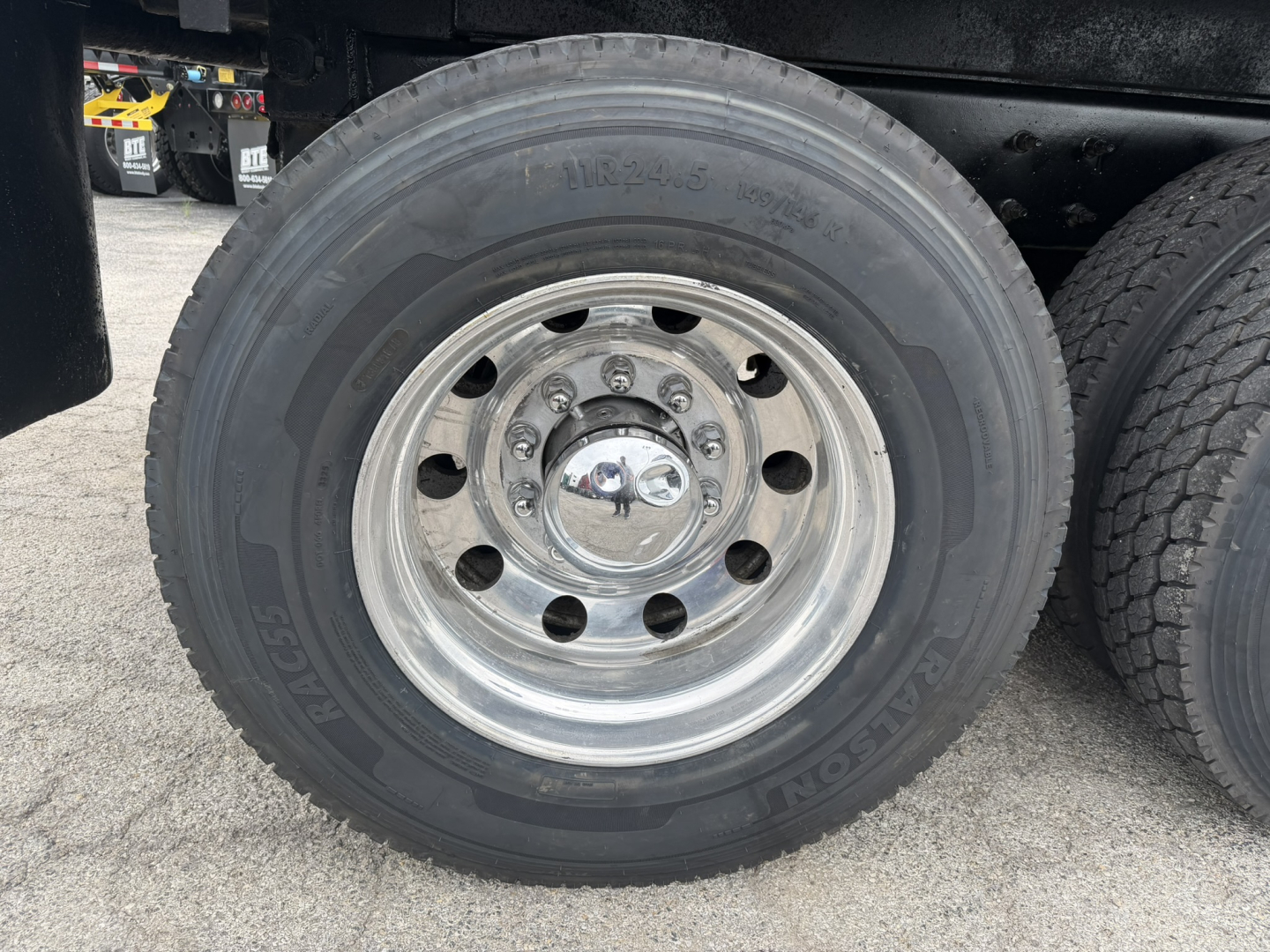 Mack GR64F wheel and tire showing polished steel rim and tire with GM model details visible.
