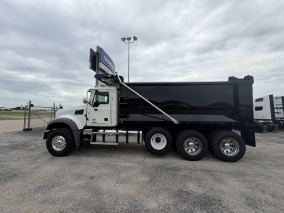 2021 Mack GR64F dump truck side view showing VIN plate in the cab area and multiple axles with a black dump body.