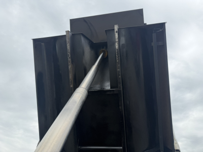 Dump truck bed inner structure with hydraulic ram and steel sides.