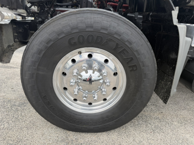Mack GR64F truck front wheel close-up showing Goodyear tire and polished steel hub with lug nuts.