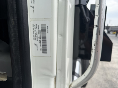 Label with VIN and stock number on Mack GR64F truck door jamb showing MACK TRUCKS INC, VIN 1M2GR4GCXMM022853, stock B3432P.