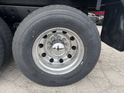 Wheel of a 2021 Mack GR64F dump truck showing a single steel wheel with bolt pattern and tire marking.